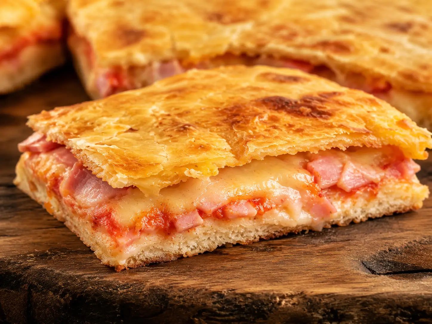 Parigina in teglia con pomodoro, prosciutto cotto, formaggio e pasta sfoglia dorata